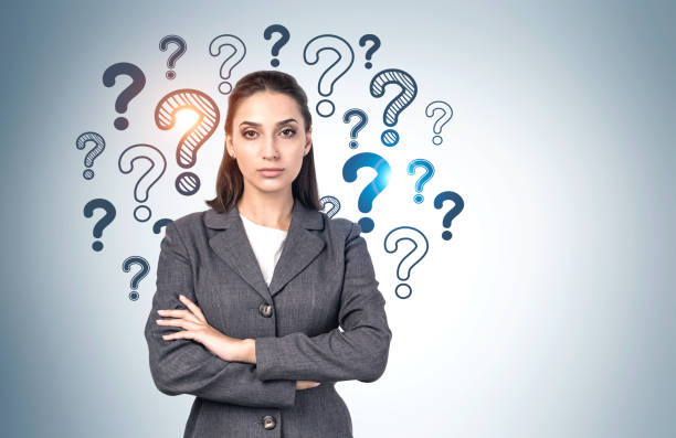 istock Confident young businesswoman, question marks 1254364404