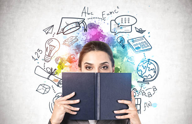 istock Student covering face with book, education icons 1254364817