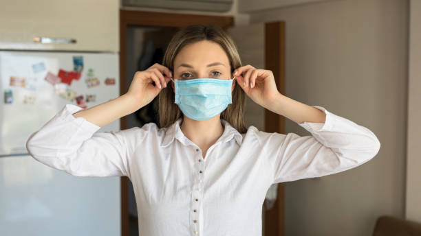 istock Young woman putting on a protective mask for isolation 1254366228