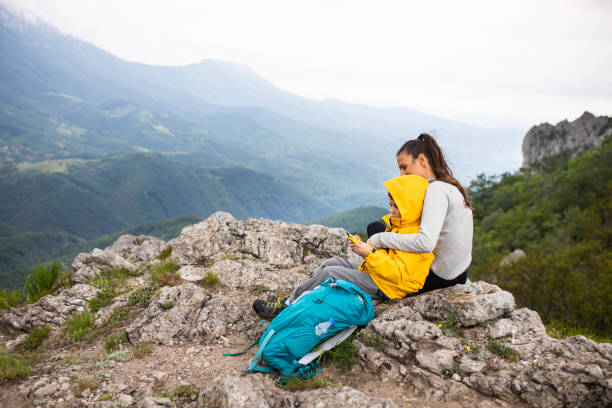 istock Mom hugging her young son while resting from hiking 1254366677