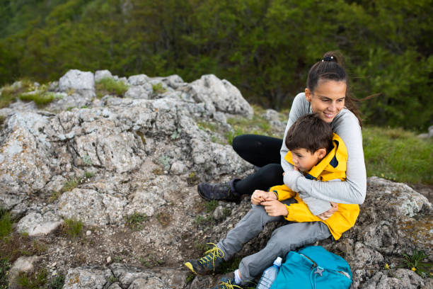 istock Mom and son hugging on a mountain ridge 1254366696
