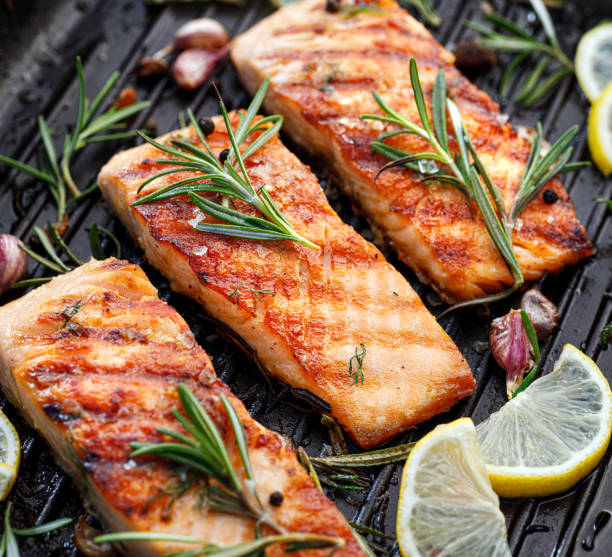 istock Grilled salmon fillets sprinkled with fresh herbs on a grill plate 1254368976