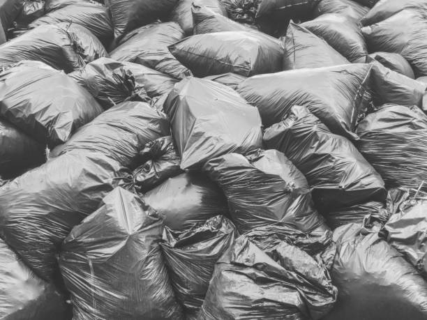 istock Black plastic garbage bags. Ecology concept background 1254369788