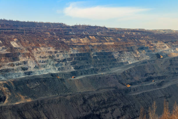istock Huge iron ore quarry with working dump trucks and excavators 1254373043