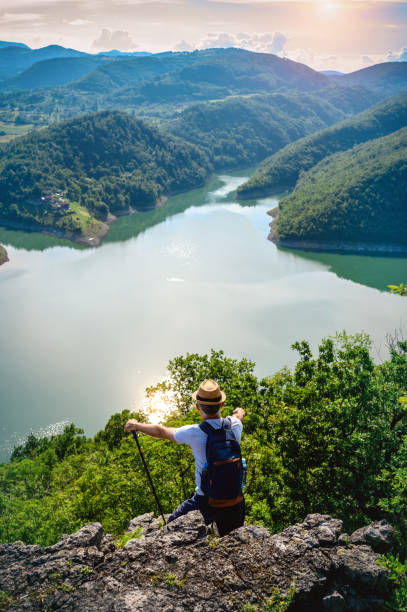 istock Hiker stands on a mountain top and admires view 1254373061