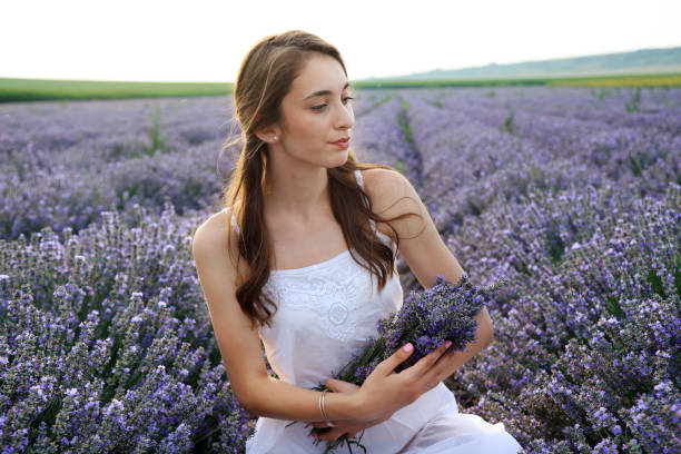 istock Young girl in lavender field holding bouquet 1254374001