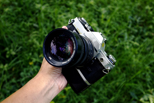 Old and vintage single lens reflex or SLR film camera at an outdoor park