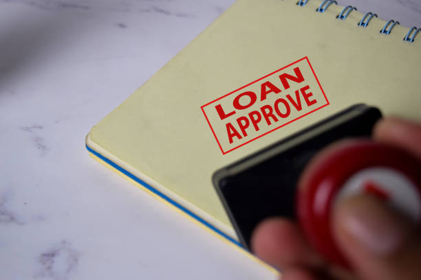 istock Red Handle Rubber Stamper and Loan Aprroved text isolated on White Background. 1254374158
