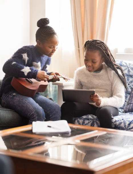 это приложение лучше всего подходит для изучения музыки в домашних условиях - sofa music teenager friendship стоковые фото и изображения
