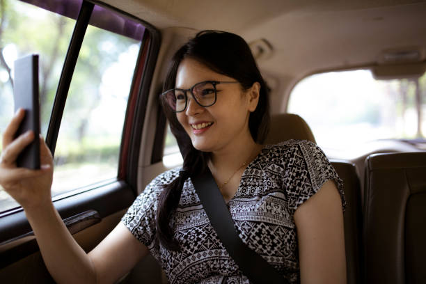 istock Asian woman using phone while traveling by a taxi 1254376986