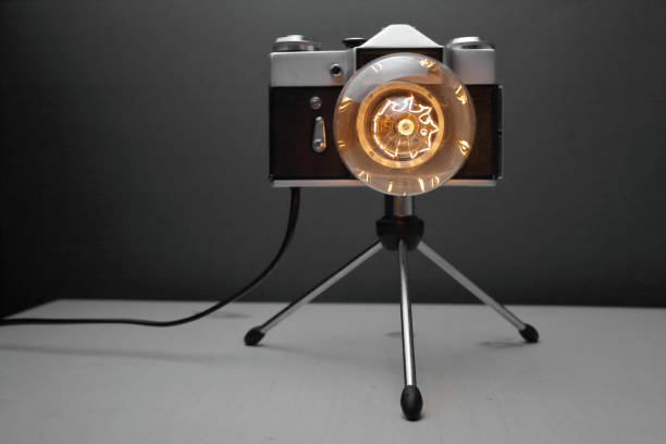 istock Retro lamp from an old camera with an Edison lamp on a gray background. Concept is a good idea. 1254383494
