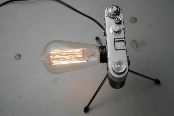 istock Retro lamp from an old camera with an Edison lamp on a gray background. Concept is a good idea. 1254385223