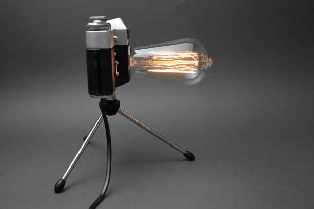 istock Retro lamp from an old camera with an Edison lamp on a gray background. Concept is a good idea. 1254385425