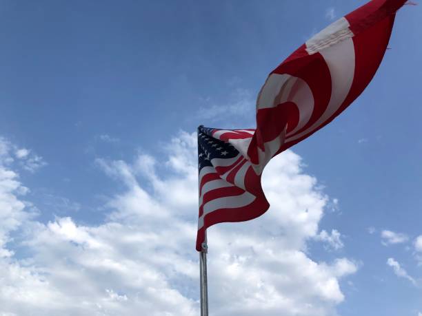istock United States flag on a pole with blue sky and clouds 1254386554