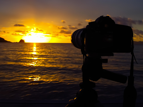 a view behind the camera which about to shoot sunset at the sea.