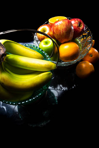 istock Arrangement with fruits on a shiny black surface with black background. 1254387012