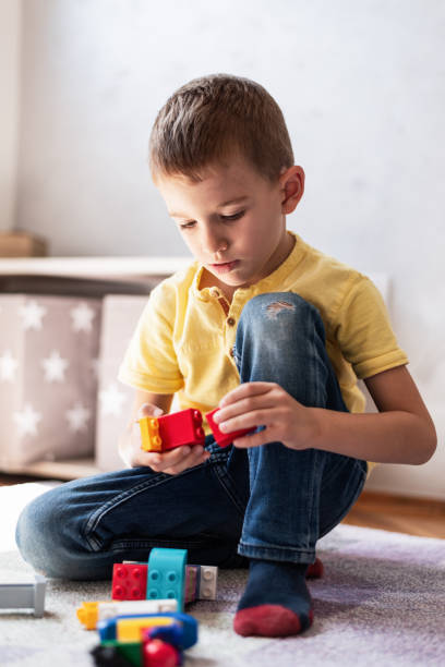 istock Happy boy playing with colorful building blocks 1254388772