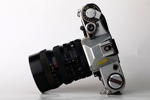 Photo of an old and vintage single lens reflex or SLR film camera isolated on white background.