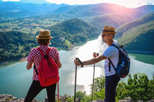 istock Hikers stands on a mountain top and admires view 1254389948