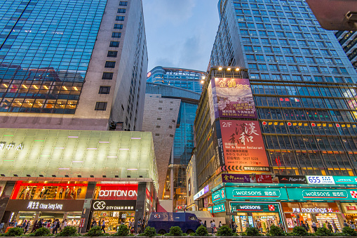 People walking in the street during dusk at downtown Hong Kong city.