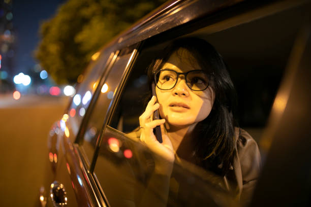 istock Asian woman with mobile phone in a car 1254400531
