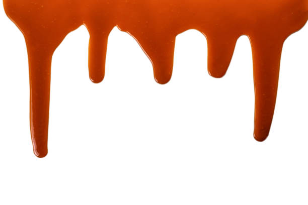 istock Background of flowing caramel sauce isolated on white. 1254400761