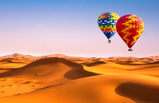 Travel concept. Amazing view of sand dunes with hot air balloons in the Sahara Desert. Location: Sahara Desert, Morocco. Artistic picture. Beauty world.
