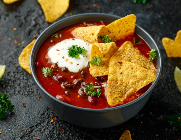 istock Mexican Chilli bean soup with yogurt, cheese and tortilla chips in black bowl 1254405053