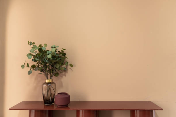 istock Nice artificial plant in glass vase with red ceramic vase setting on empty red table in minimal modern style apartment / residential interior concept / copy space 1254408423
