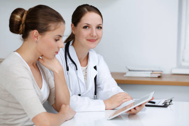 istock Doctor and patient are sitting and discussing health examination results while using tablet computer. Health care, medicine and good news concepts 1254409314