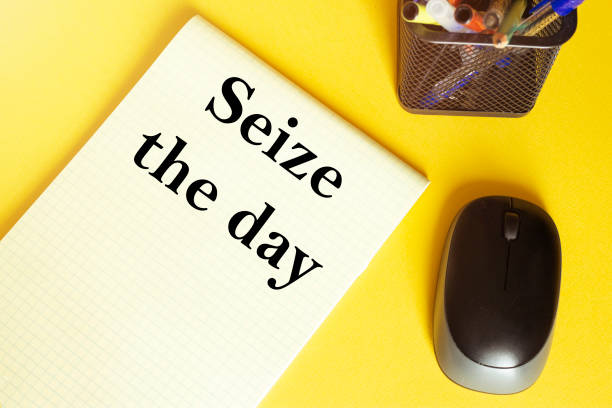 computer mouse, pens, felt-tip pens, notepad with text Seize the day on a yellow background