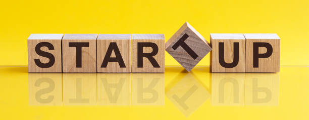 istock startup word written on wood block. startup text on table, concept. 1254411502