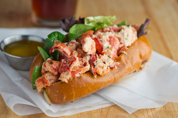 Lobster roll. Maine lobster mixed with mayo, celery, onions, garlic, scallions, chives, lemon juice. Lobster roll on toasted hotdog bun w/ lettuce, tomato, garlic mayo seasoned salt & pepper. Classic American restaurant or diner lunch sandwich favorite. Lobster roll. Maine lobster mixed with mayo, celery, onions, garlic, scallions, chives, lemon juice. Lobster roll on toasted hotdog bun w/ lettuce, tomato, garlic mayo seasoned salt & pepper. Classic American restaurant or diner lunch sandwich favorite. pastrami photos stock pictures, royalty-free photos & images