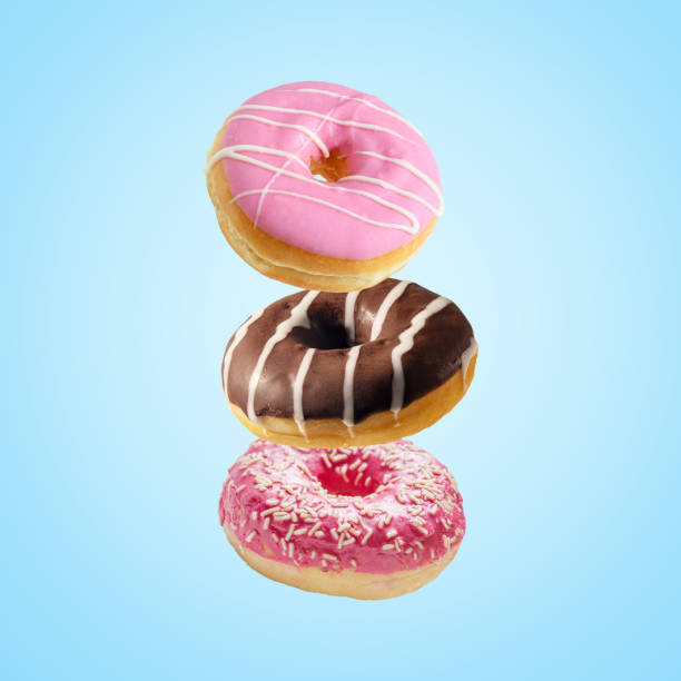 istock Different fresh donuts on blue background. Minimal food concept. 1254412946