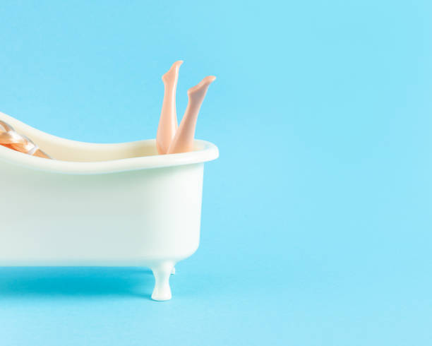 istock Doll takes a bath on blue background. Minimal summer relax concept. 1254412966