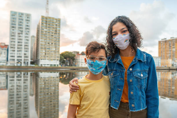 People with N95 respiratory mask in front of the Capibaribe river in Recife, Pernambuco state.