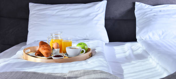 istock Breakfast on tray in bed in hotel room 1254416194