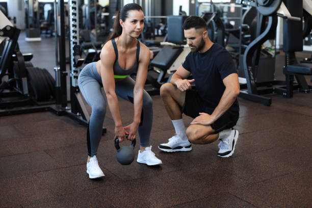 istock Fitness instructor exercising with his client at the gym. 1254418541