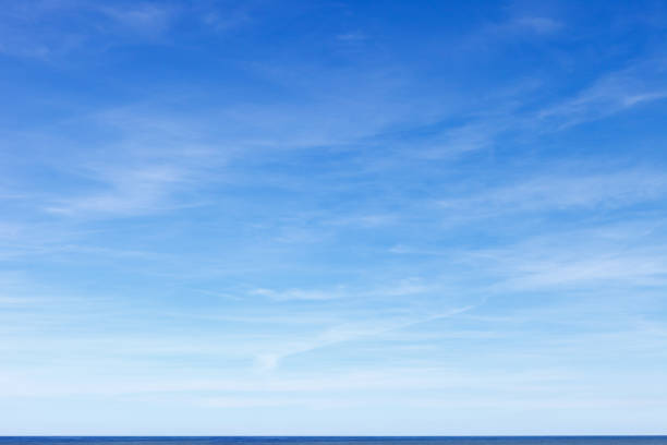 schöner blauer himmel mit zirruswolken über dem meer. skyline. - blau stock-fotos und bilder