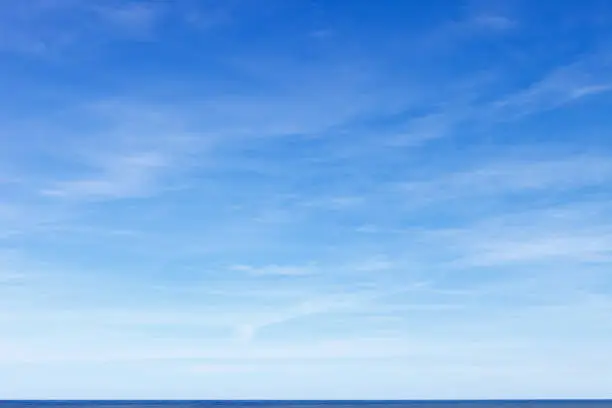 Photo of Beautiful blue sky with cirrus clouds over the sea. Skyline.