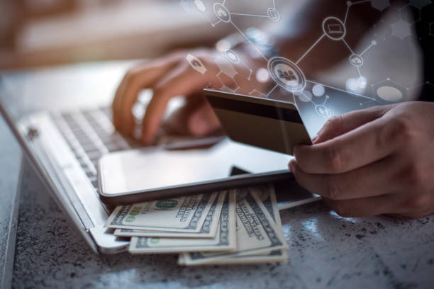 istock Side view of male hands holding credit card typing numbers on computer keyboard while sitting at home  soft focus, flare sun light, cross process image 1254422328