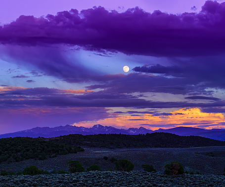 New York Mountains Moonrise Sunset - Nearly full moon rising over rugged peaks in the Sawatch Range. Summer landscape mountain scenic view with nobody and copy space. Colorado Rocky Mountains, USA.