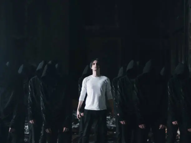 man in white with followers in black cult concept