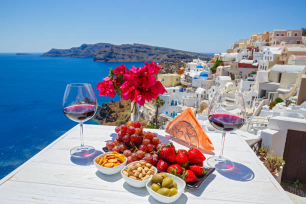 Wine, snacks and fruit on the table Wine, snacks and fruit on the table with a view of the Greek sea santorin stock pictures, royalty-free photos & images