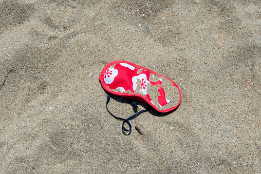 Red face mask left at English Bay, Vancouver, Canada