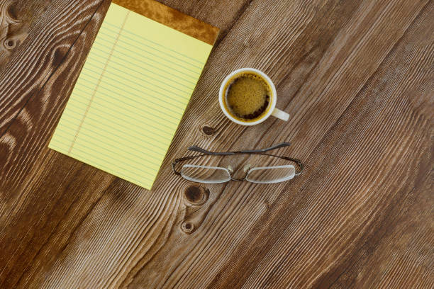 istock Workspace office desk with blank notebook espresso coffee glasses on wooden background 1254433425