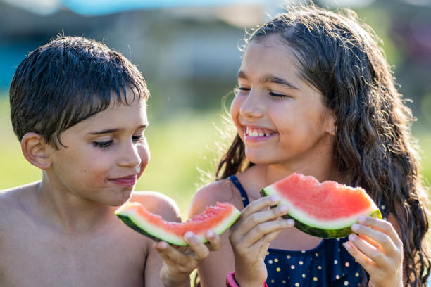 istock Hispanic siblings enjoying watermelon on a sunny afternoon 1254438882