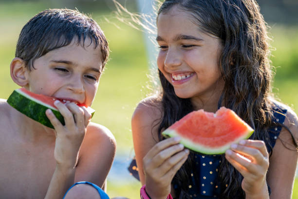 istock Hispanic siblings enjoying watermelon on a sunny afternoon 1254438887
