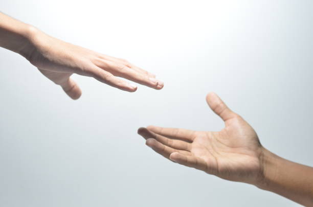 istock Two male hands reaching towards each other on isolated white background 1254441021