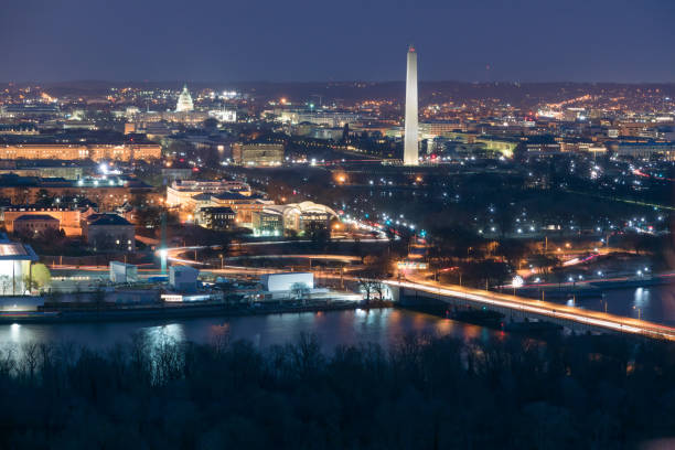 Aerial View of Washington DC at Night Illuminated Washington DC at night with the Washington Monument and the US Capitol and the Potomac River in the foreground potomac river photos stock pictures, royalty-free photos & images